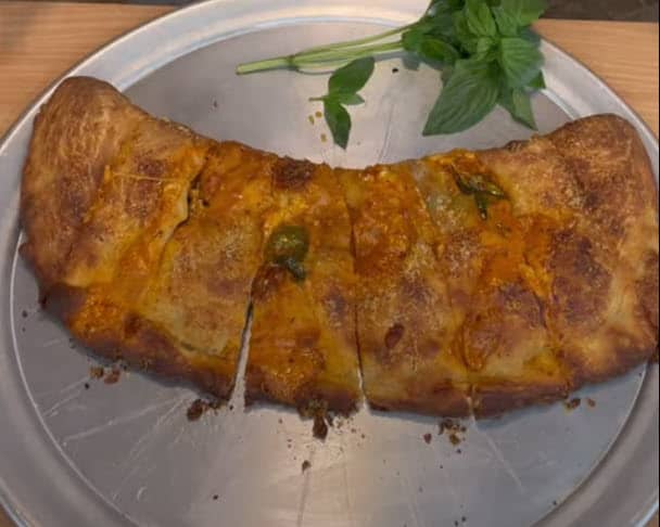 A calzone on a metal plate.
