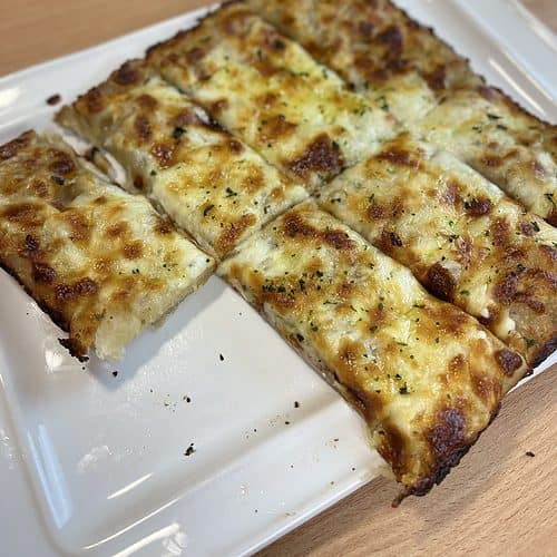 Cheesy Bread Sticks on a white plate.