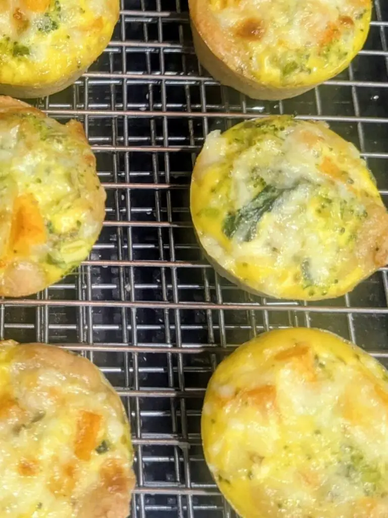 High protein pizza dough breakfast cups with golden crusts cooling on a wire rack.
